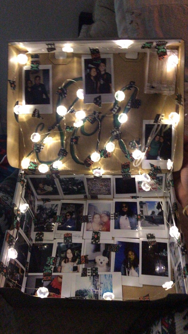 an open suitcase filled with pictures and lights on the inside, in someone's hand