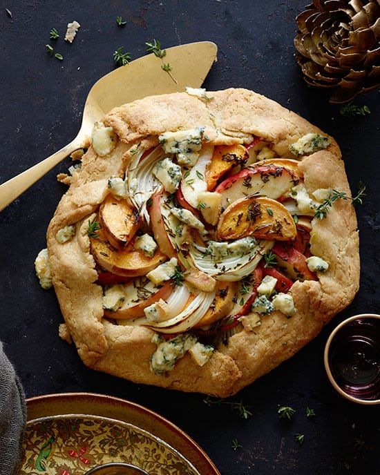 a pizza with onions, cheese and herbs on it next to other food items such as sauces