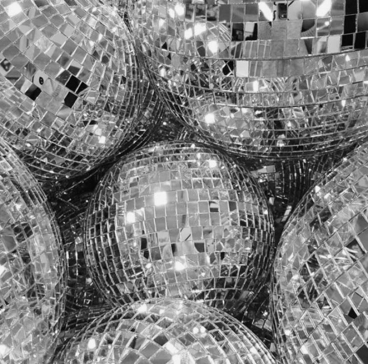 many disco balls are stacked together in black and white