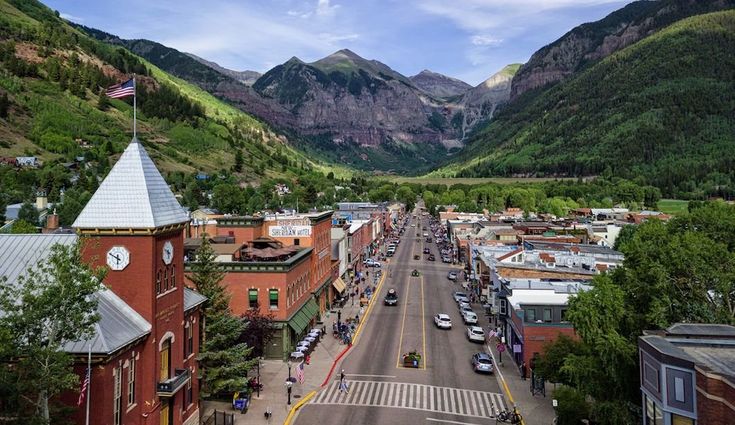 an aerial view of a town with mountains in the background