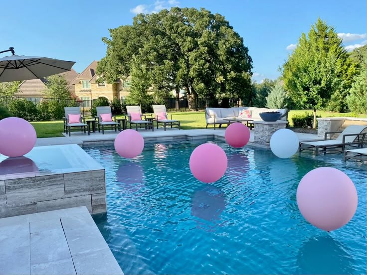 balloons floating in a pool with chairs and tables