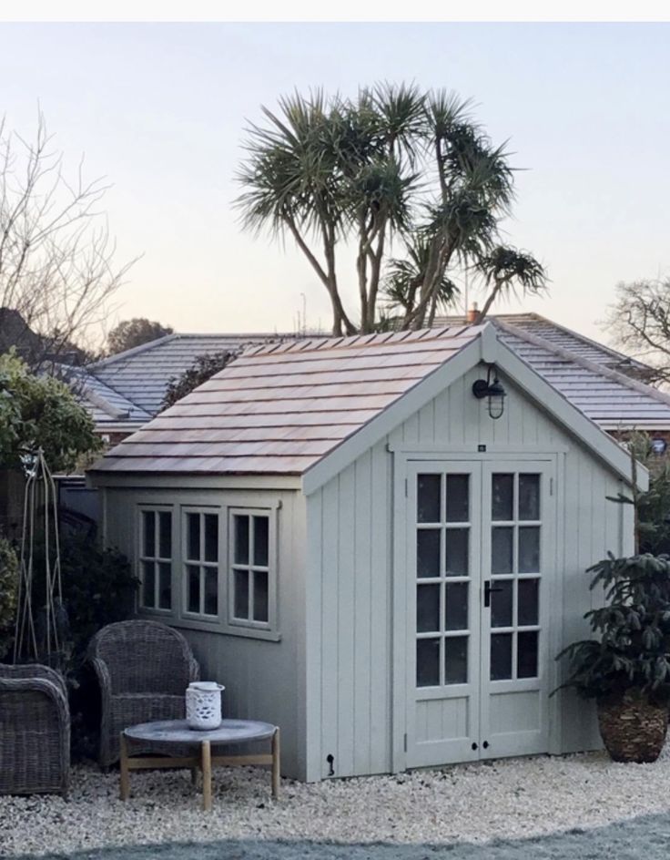 a small white building sitting next to a palm tree