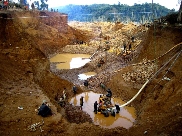 people are standing in the middle of a muddy area with water coming out of it