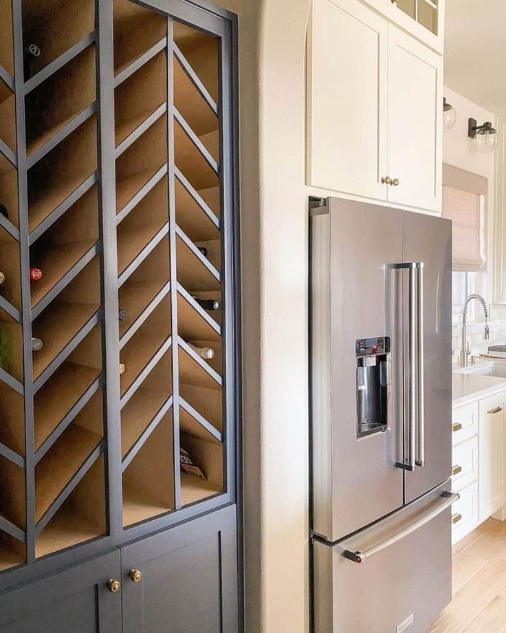 a stainless steel refrigerator with wooden shelves in a kitchen