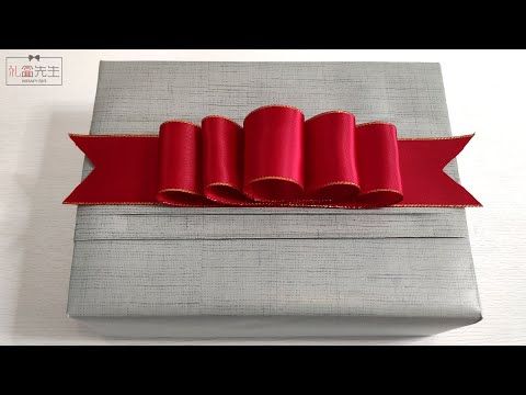 a gray box with red ribbon on it