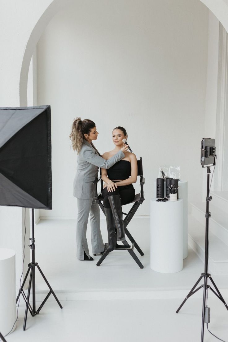 two women sitting on chairs in front of a camera