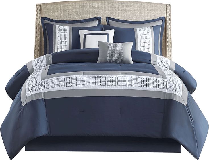 a bed with blue and white comforters on it