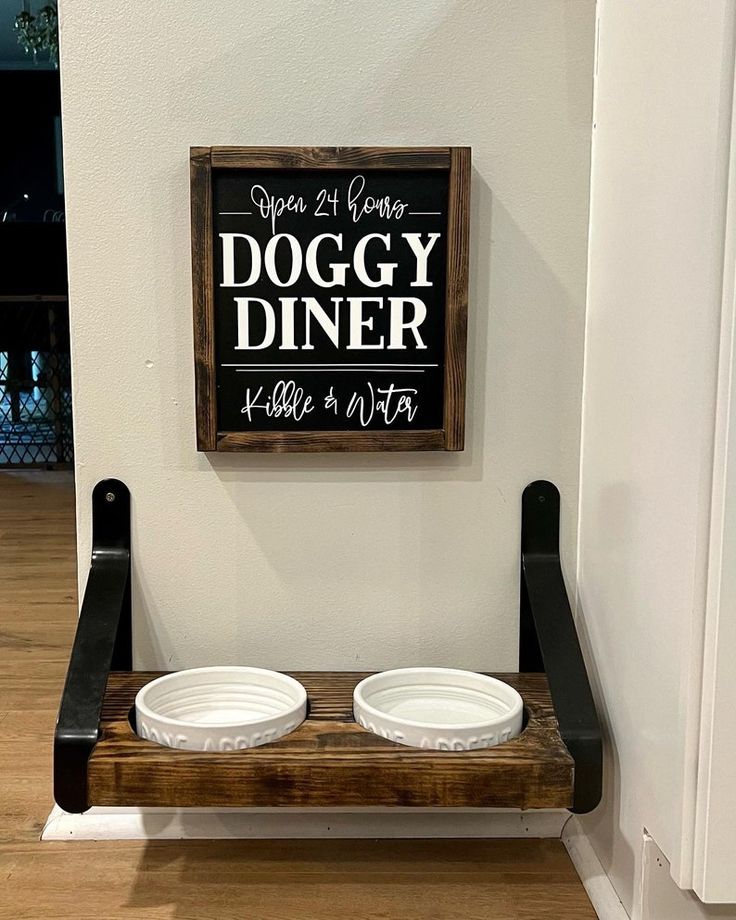 two white bowls are sitting on a wooden shelf in front of a sign that says doggy diner