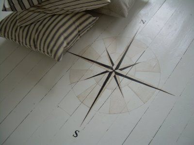 a compass is on the floor next to pillows