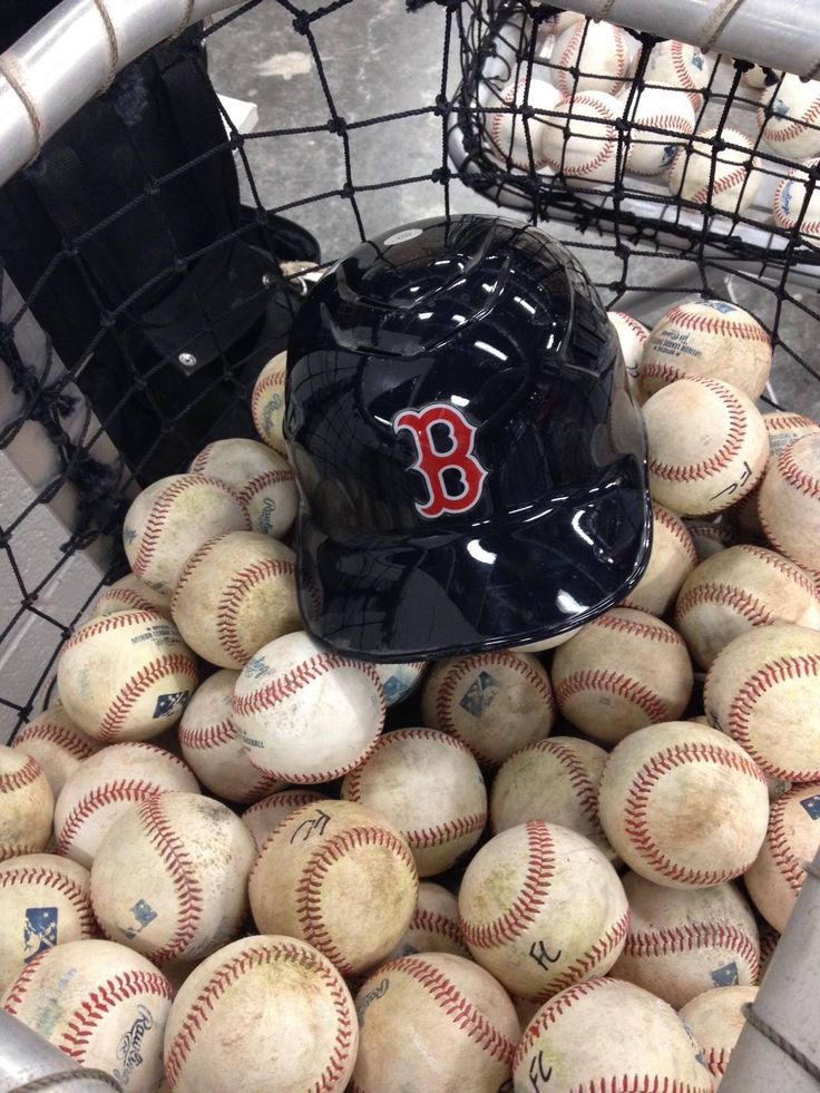 a basket full of baseballs with a helmet on top