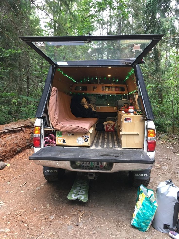 the back end of a truck with its trunk open and camping gear in the bed