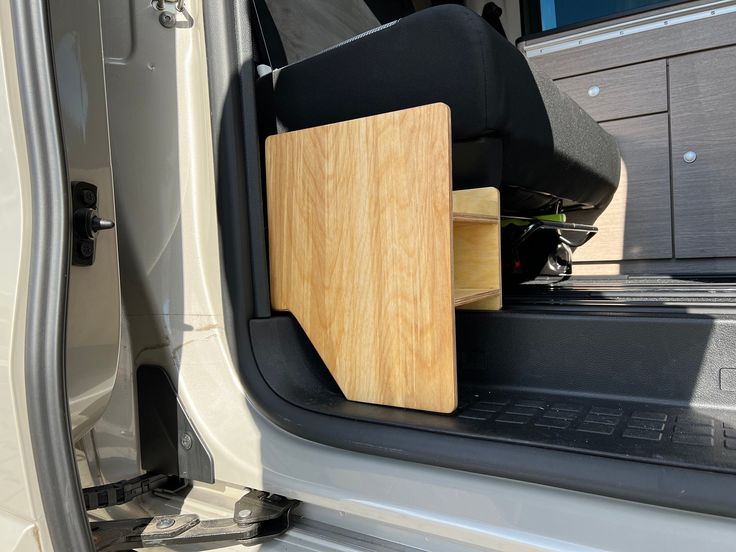 the back end of a white van with a wooden box in it