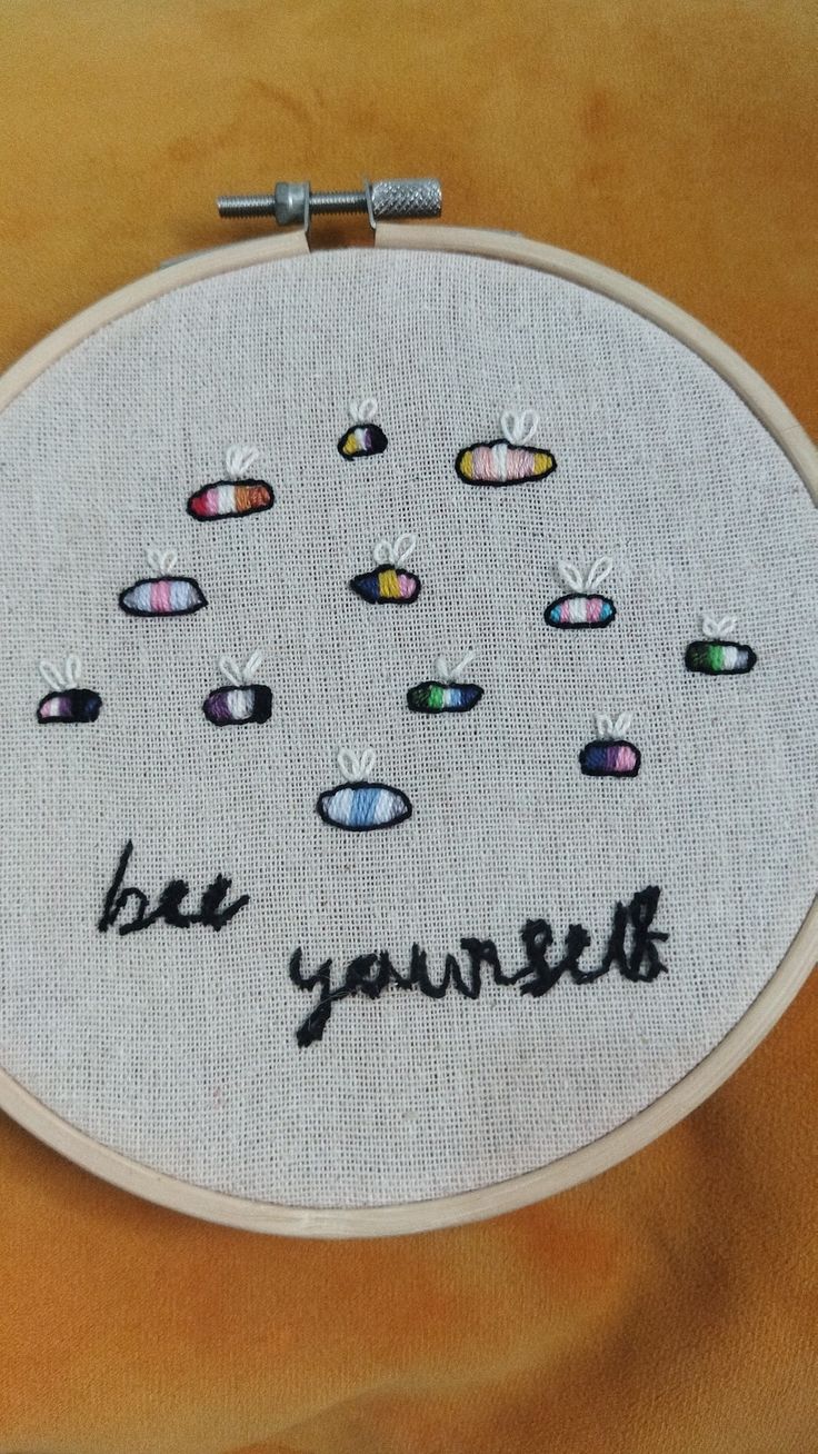 a close up of a embroidery on a piece of cloth with the words be yourself