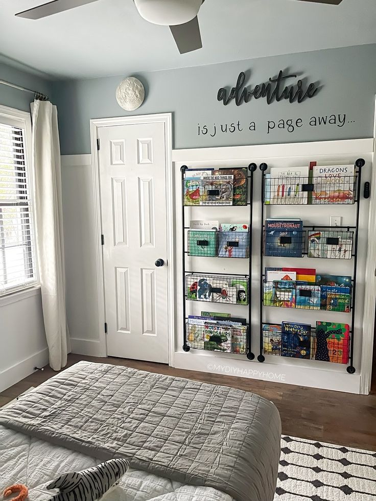 a bed sitting in a bedroom next to a wall mounted magazine rack with magazines on it