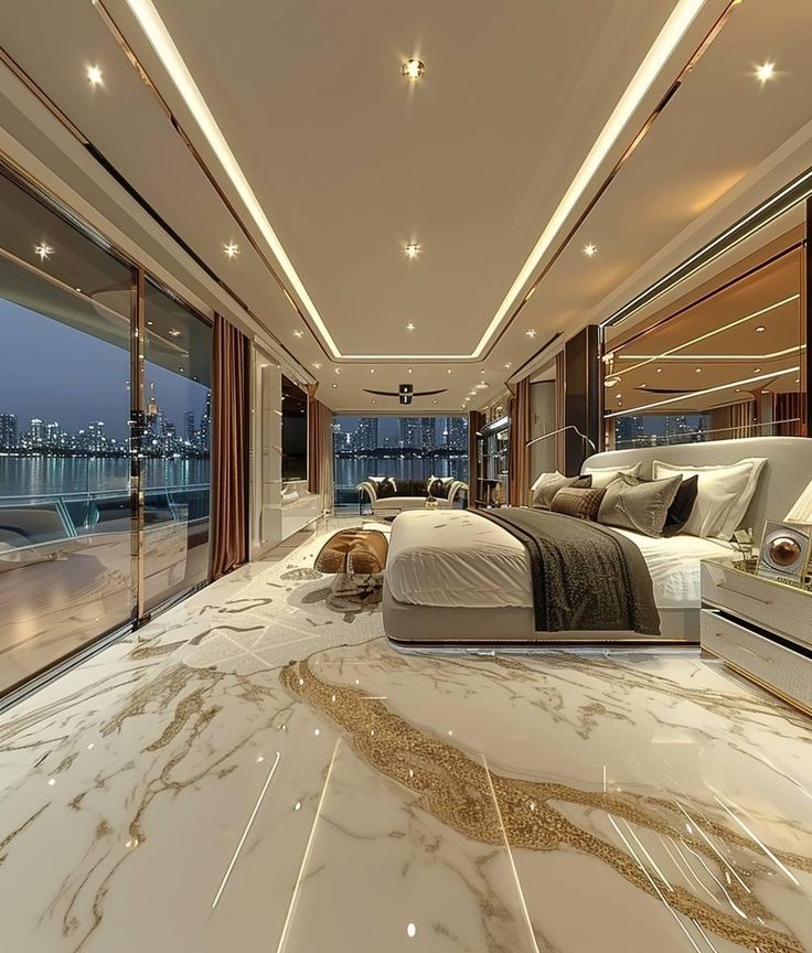 a bedroom with marble flooring and large windows looking out onto the water at night