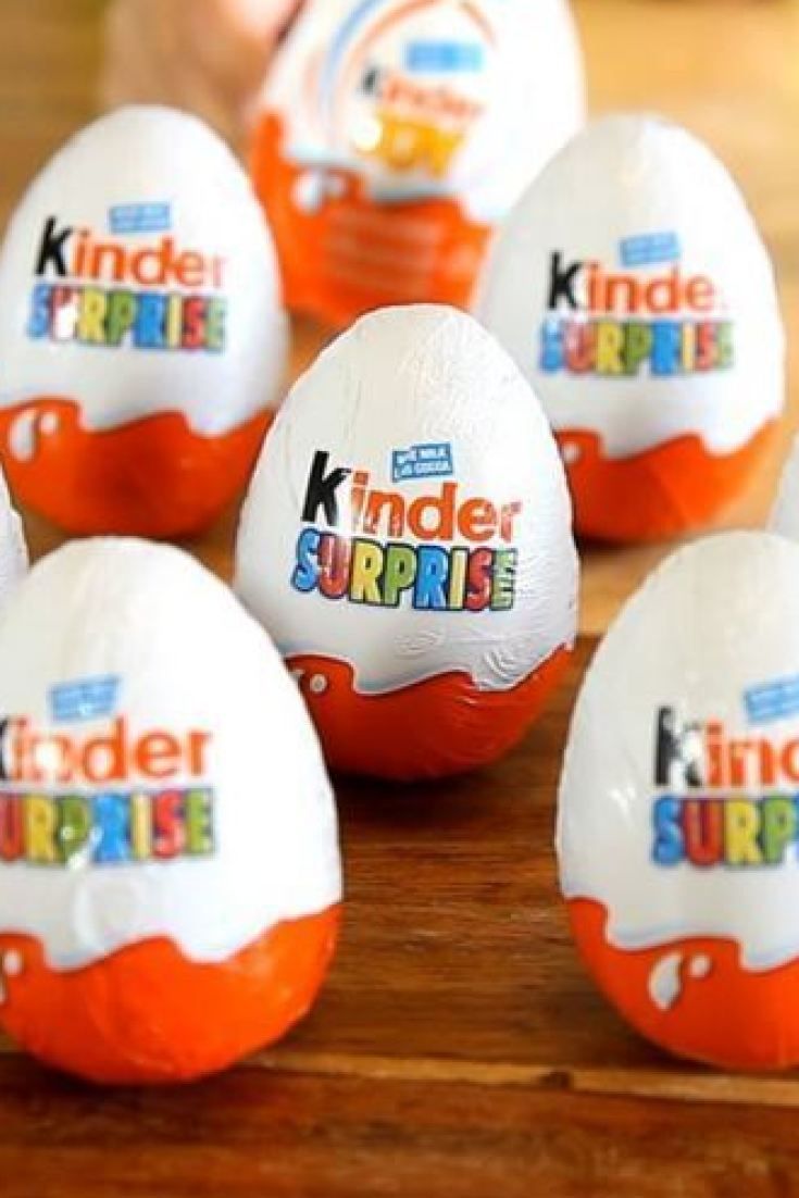 six kinder surprise eggs sitting on top of a wooden table