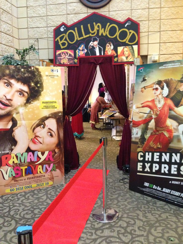 a red carpeted area with posters on the wall and a red carpet in front of it