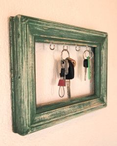 a green frame with keys hanging from it's sides and two key holders in the middle