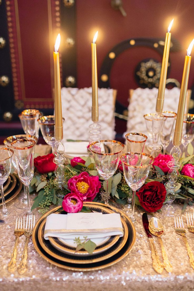 the table is set with candles, plates and napkins for an elegant wedding reception