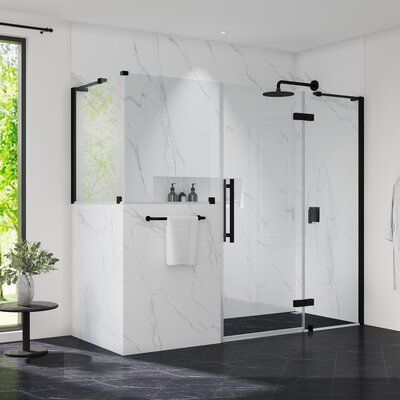 a white bathroom with black accents and marble flooring is pictured in this image, there are two shower stalls next to the tub