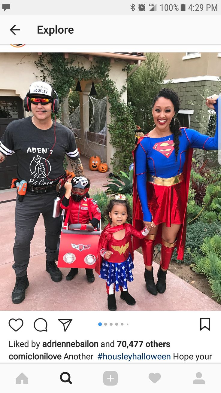 a man, woman and child dressed up as superman and wondergirl in front of a house