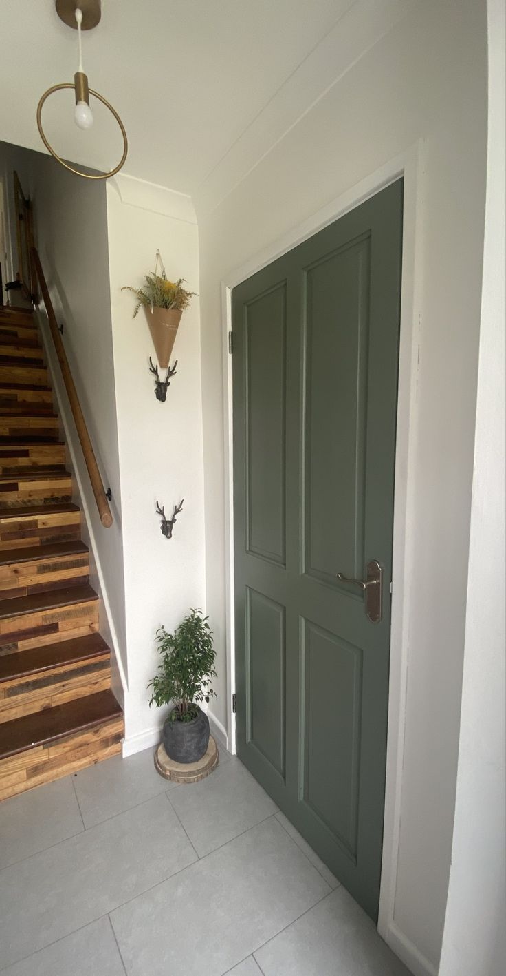 a green door and some stairs in a house