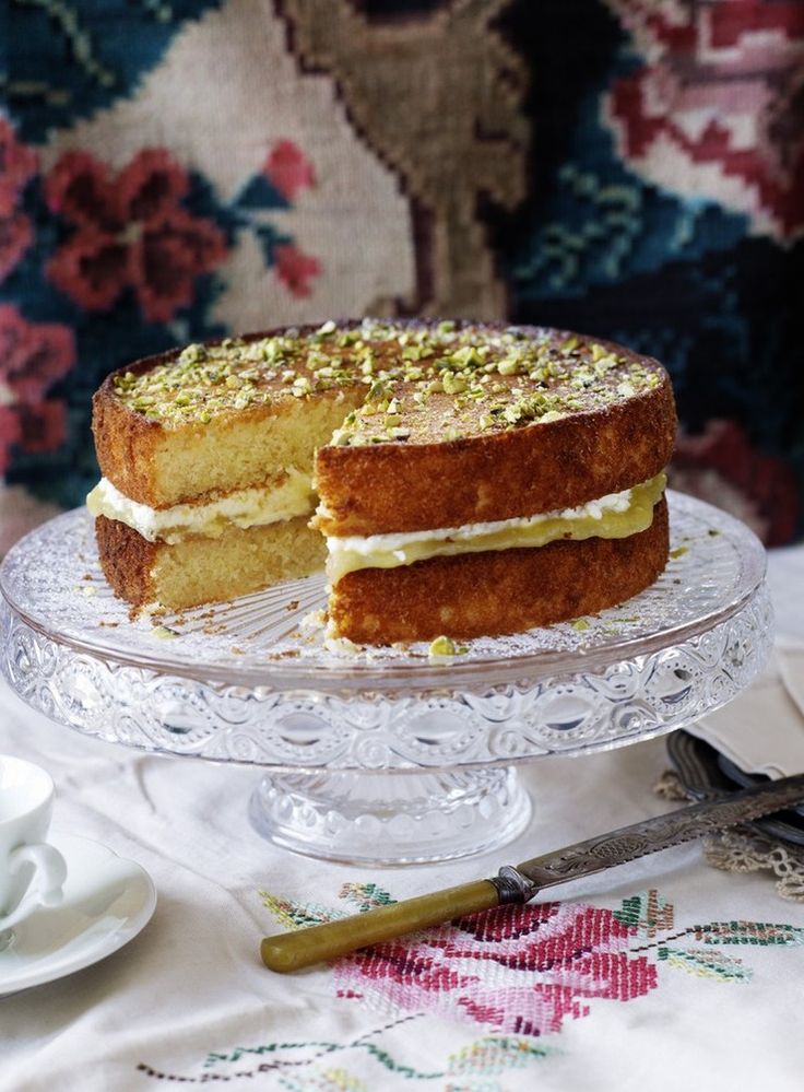 a cake sitting on top of a glass plate next to a cup and saucer