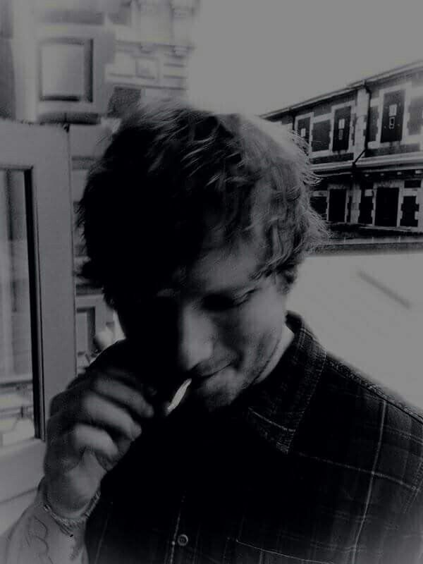 a black and white photo of a man brushing his teeth