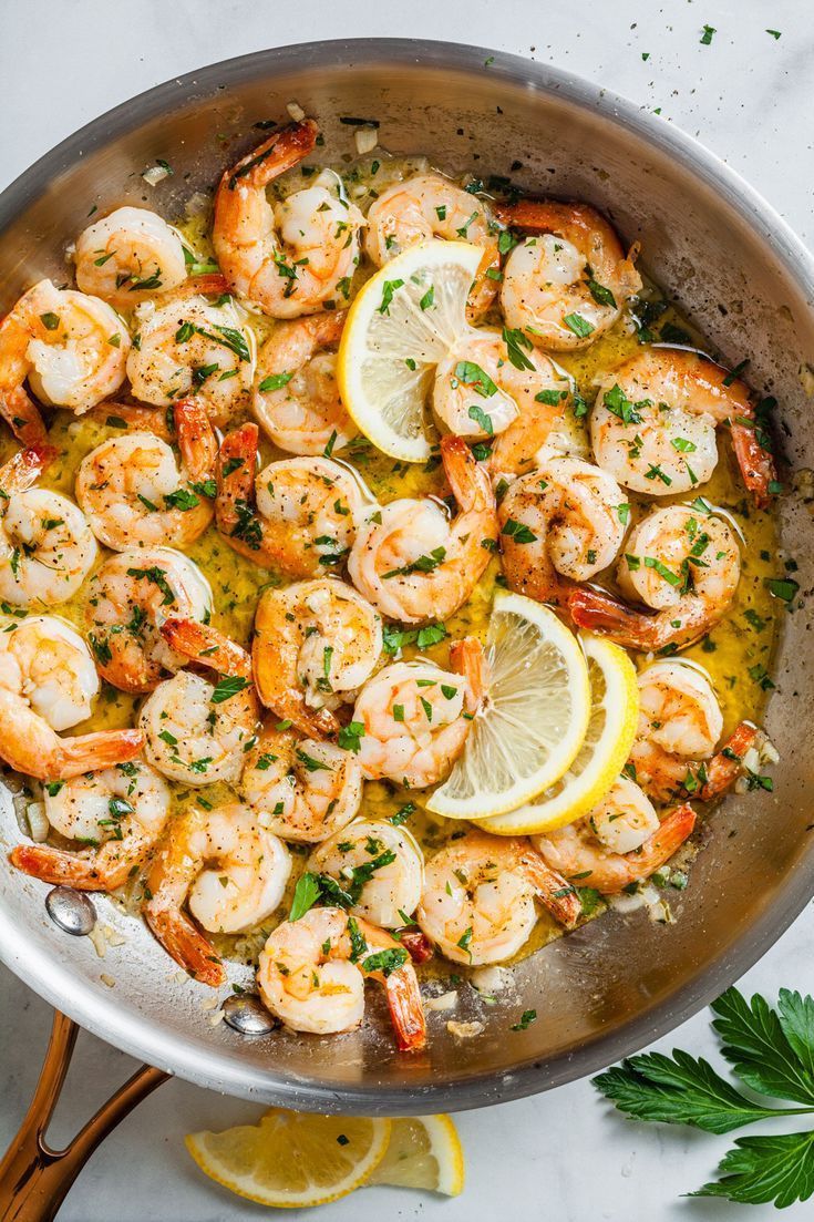 a pan filled with shrimp and lemon slices