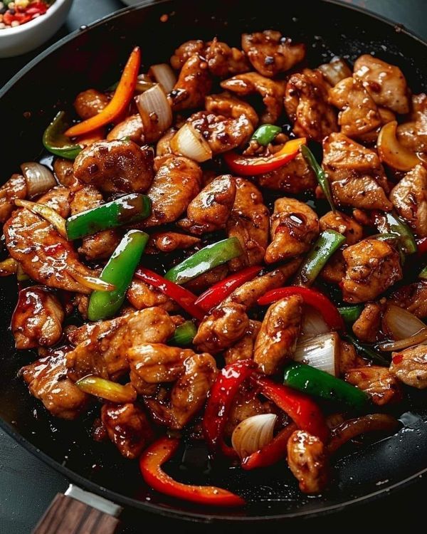 chicken with peppers and onions in a skillet