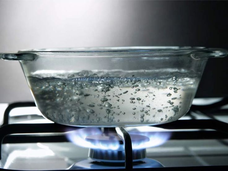 a glass bowl filled with water sitting on top of a stove