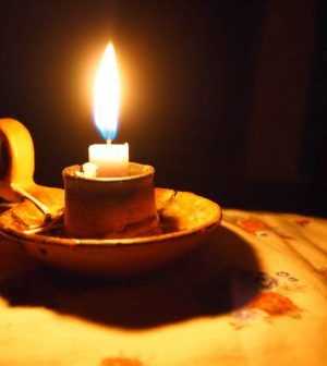 a lit candle sitting on top of a wooden plate