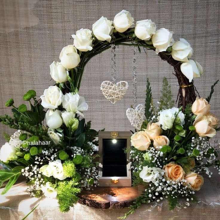 an arrangement of flowers and greenery on a table