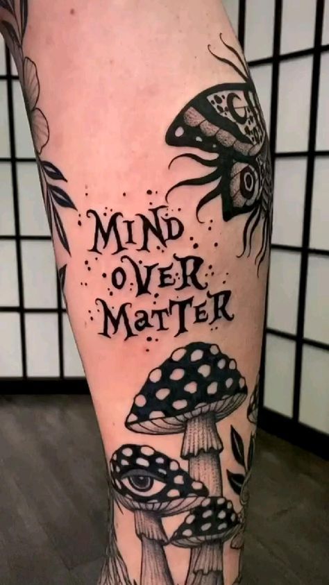 a leg with tattoos on it that says mind over matter and mushrooms in black ink