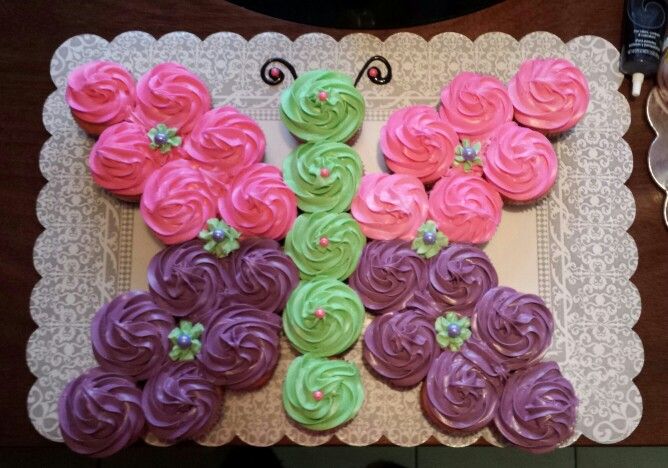 there are cupcakes in the shape of a butterfly on top of a table