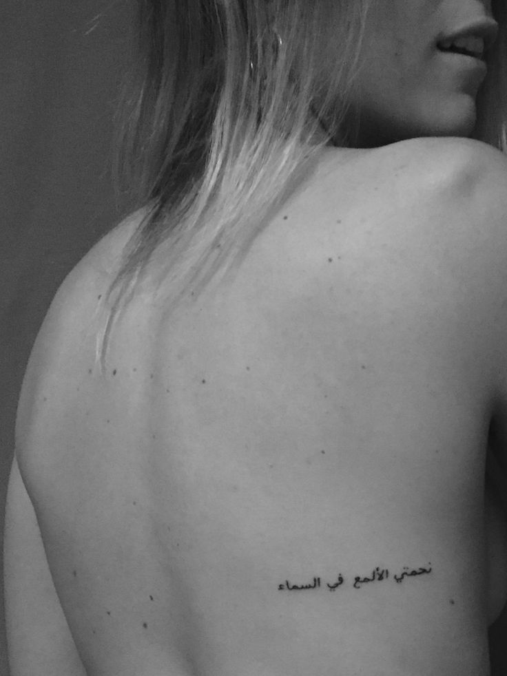 the back of a woman's shoulder with writing on it