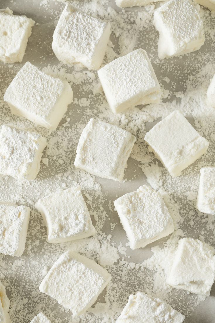 several pieces of white cake sitting on top of a pan covered in powdered sugar