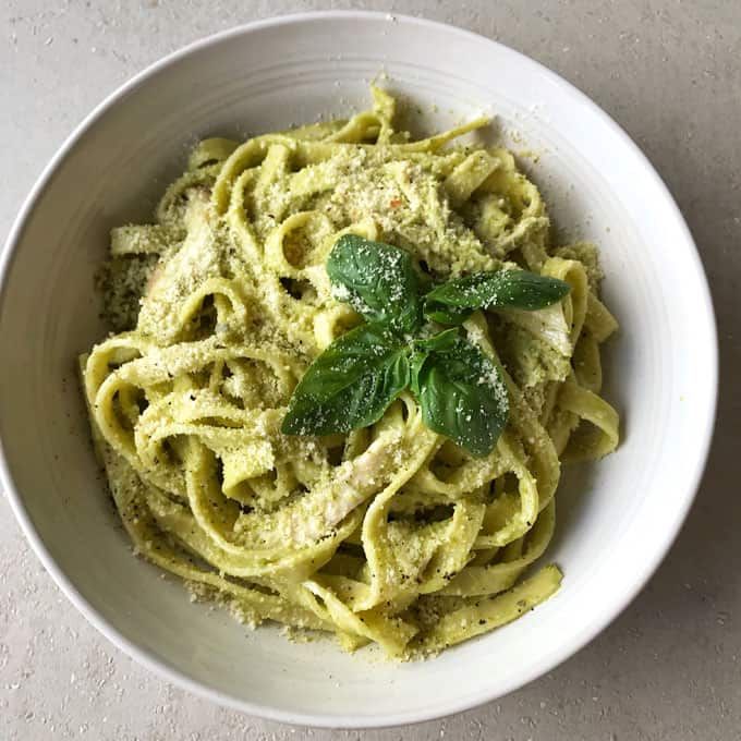 a white bowl filled with pasta and pesto