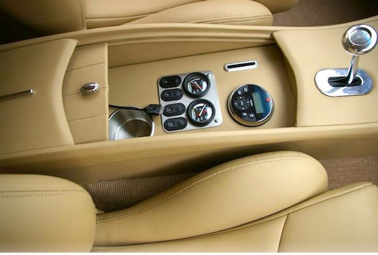 the interior of a sports car with buttons and gauges on it's center console