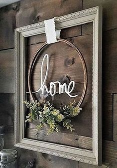 a wooden sign that says home hanging on a wall above a shelf with other items