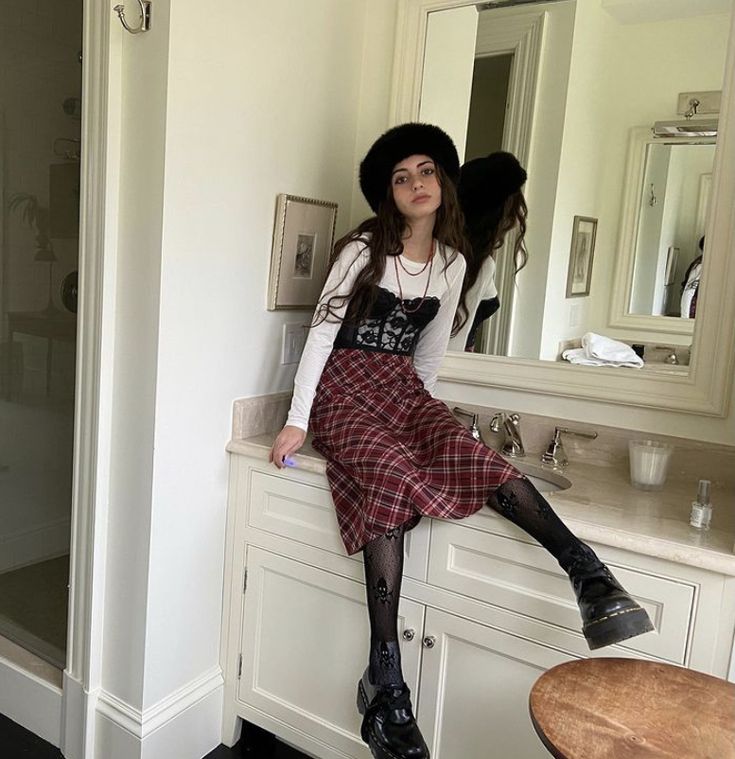 a woman sitting on top of a bathroom counter