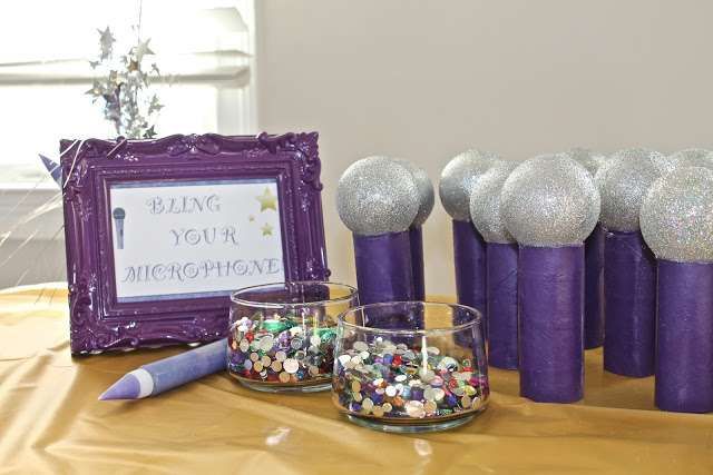 some purple candles are sitting on a table next to other items and a framed sign