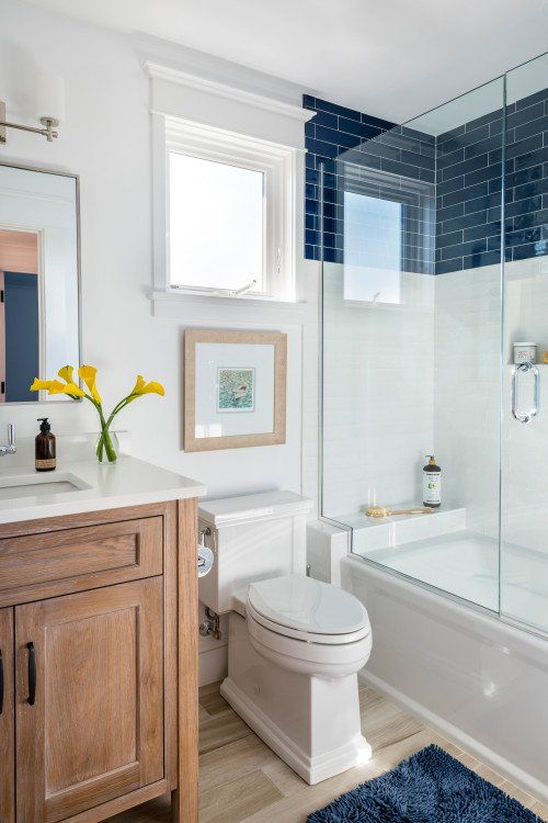 a white toilet sitting next to a walk in shower