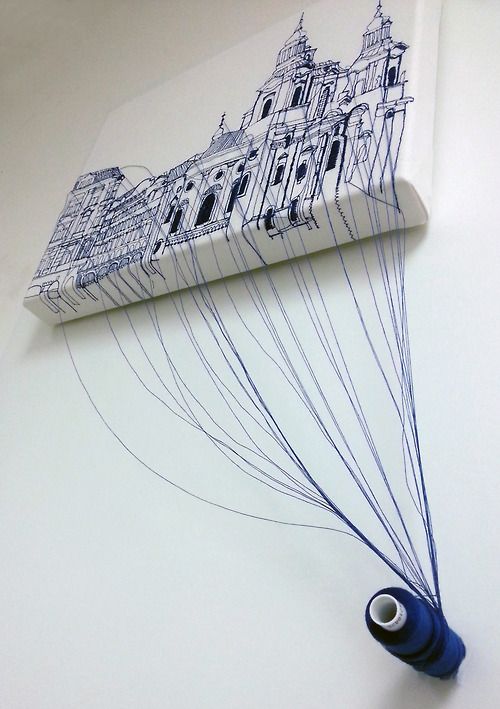 a drawing of a building is hanging on the wall next to a blue tube with black thread