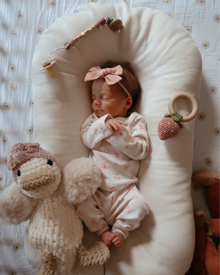 a baby sleeping next to a stuffed animal