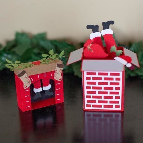 two paper christmas decorations sitting on top of a table