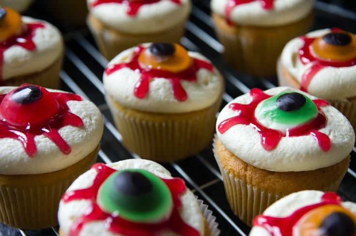 there are many cupcakes with red and green icing on them