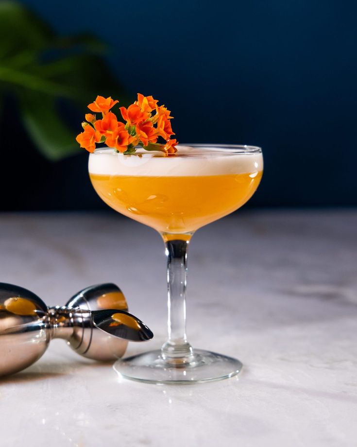 an orange flower sits on top of a cocktail