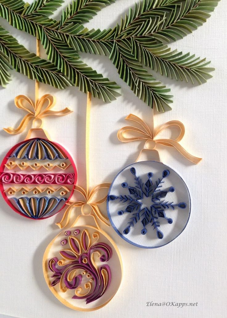 three christmas ornaments hanging from a tree branch