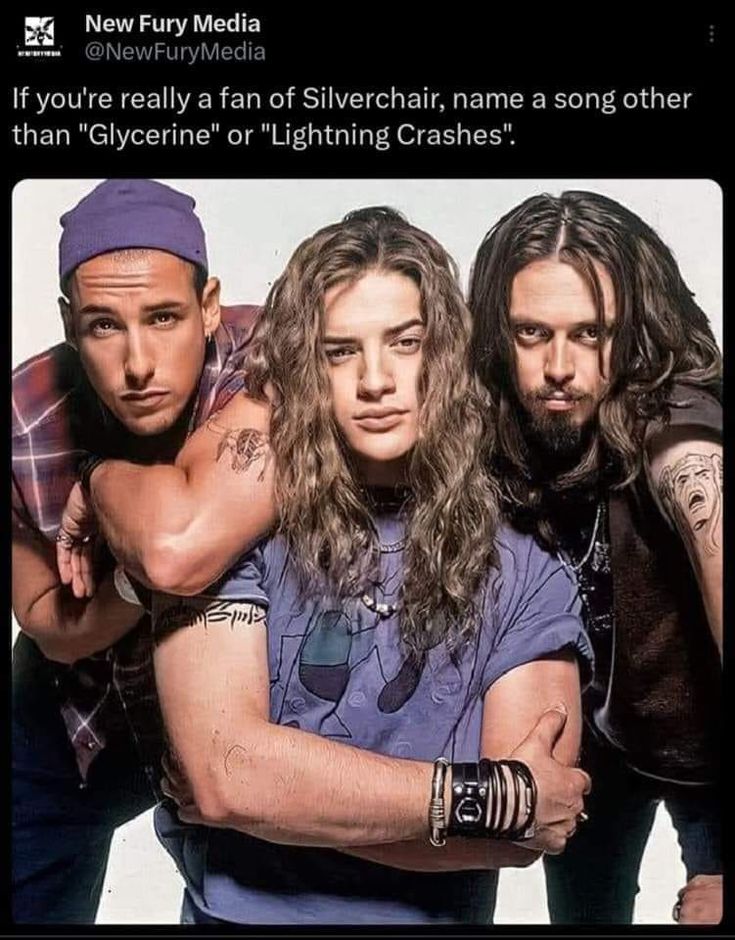 three men with long hair and tattoos posing for a photo in front of a white background